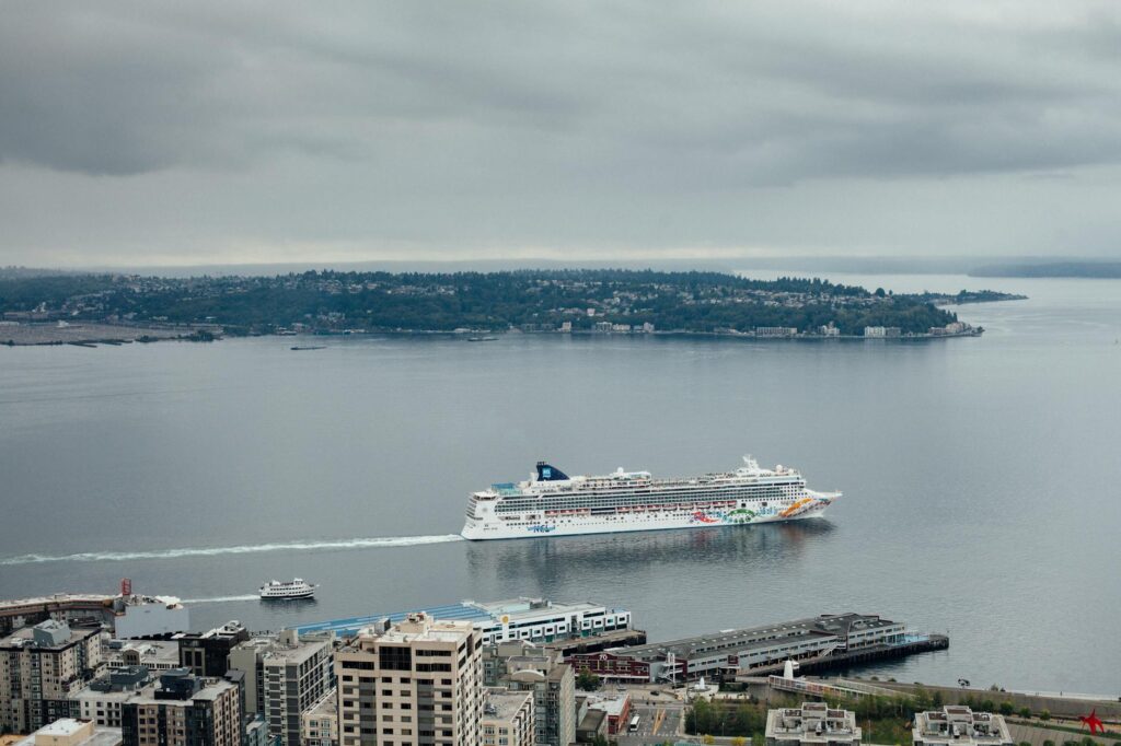 Paquebot de croisière naviguant dans la baie de Seattle avec vue sur le front de mer et les collines en arrière-plan